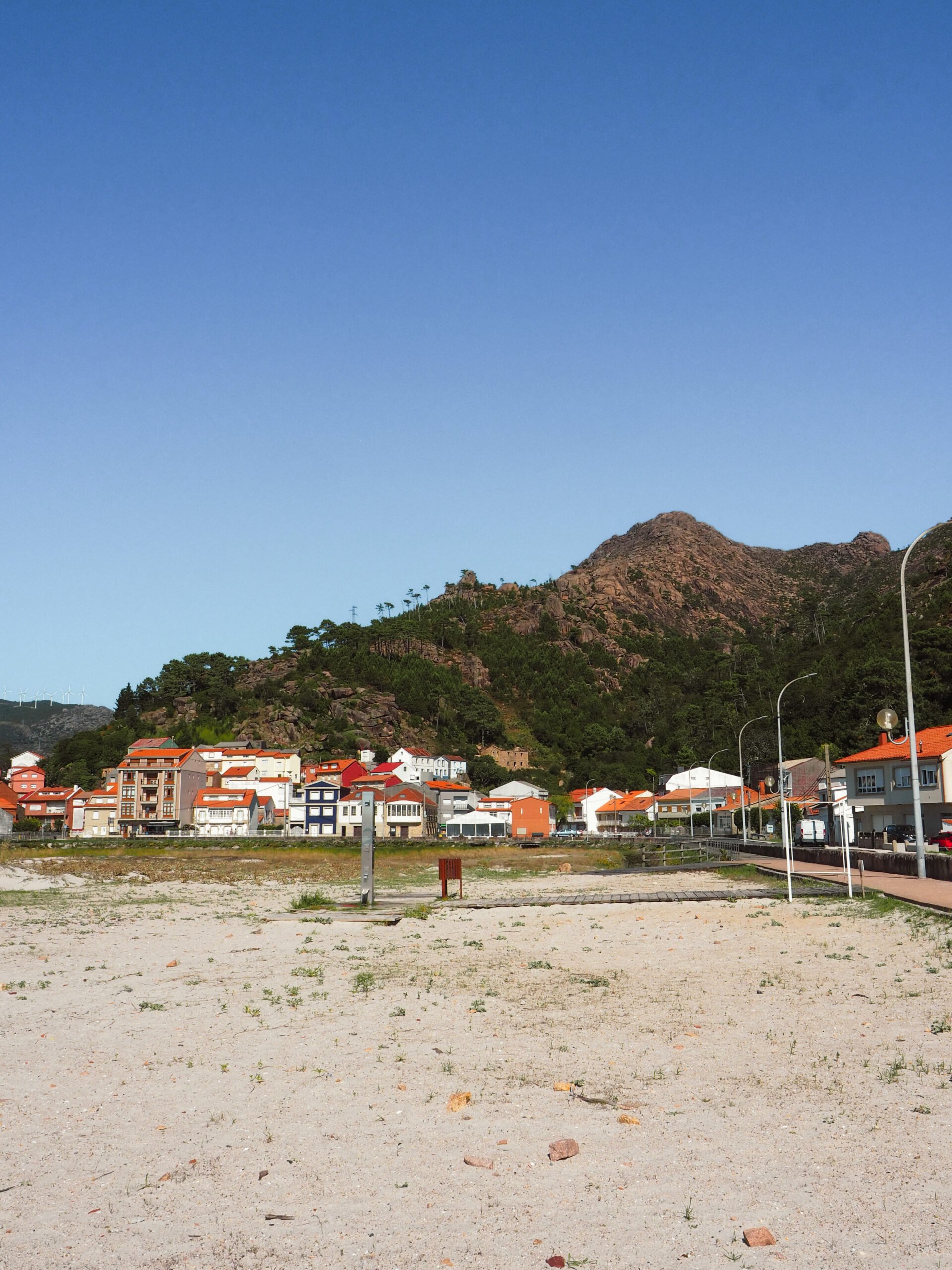 Aldeia do Pindo, na Costa da Morte, com casas tradicionais galegas junto ao mar e ao Monte Pindo.
