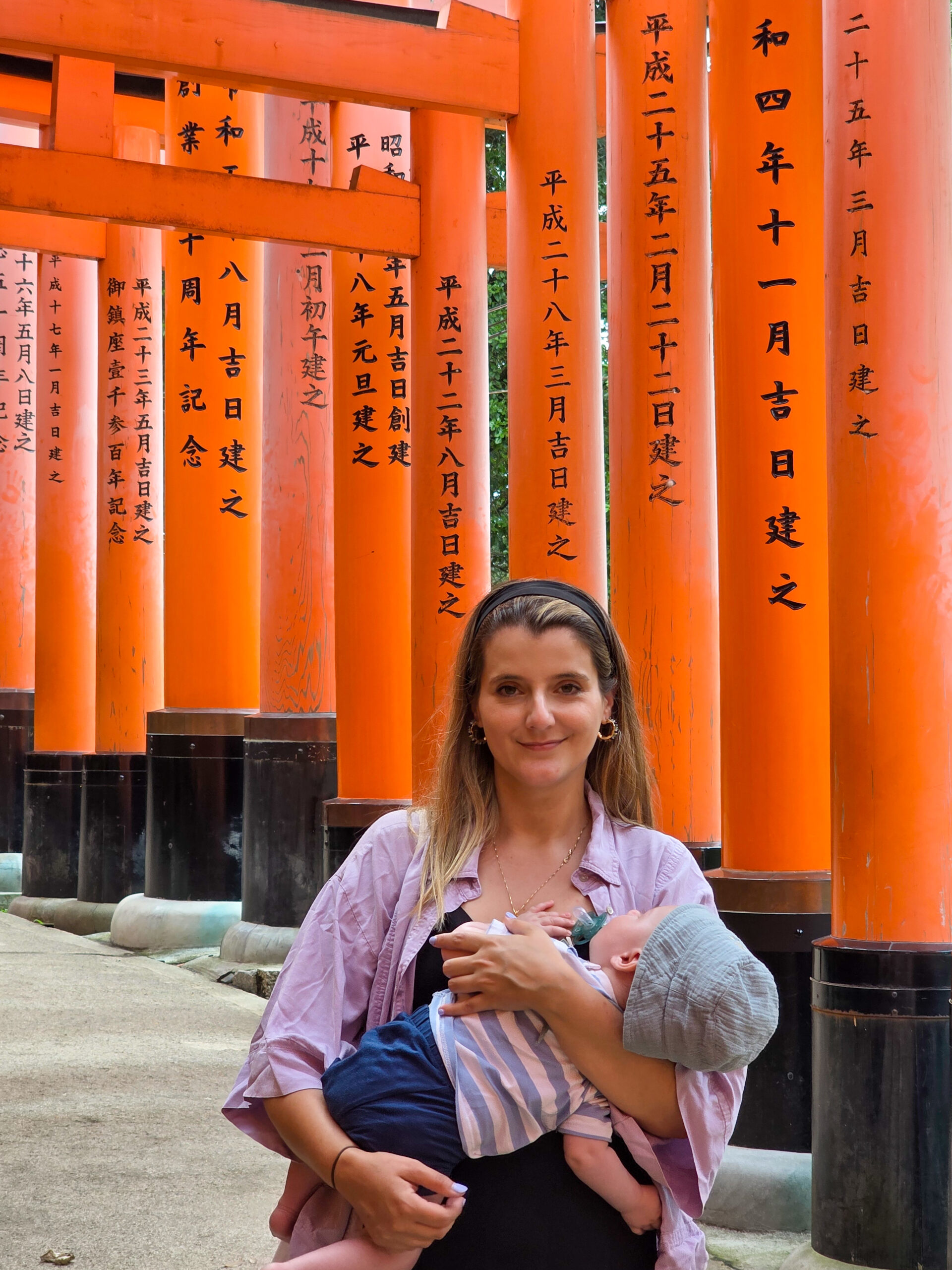 Mulher com bebé nos braços no santuário Fushimi Inari em Quioto, Japão.