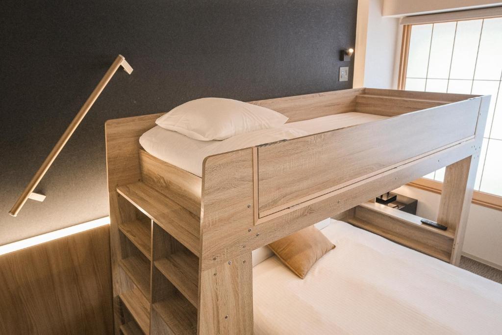 Detalhe do beliche no quarto do WAYFARER Shin em Quioto, um alojamento moderno e confortável recomendado para famílias.